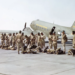 "In 1945, paratroopers of the 555th Parachute Infantry Battalion lined up in their 'jumpsuits' before embarking on a mission. Behind them stands a C-47 aircraft from the Troop Carrier Command, ready to transport them to their destination."— US National Archives